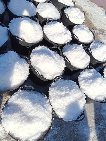 Multiple black plastic containers filled with snow. 2