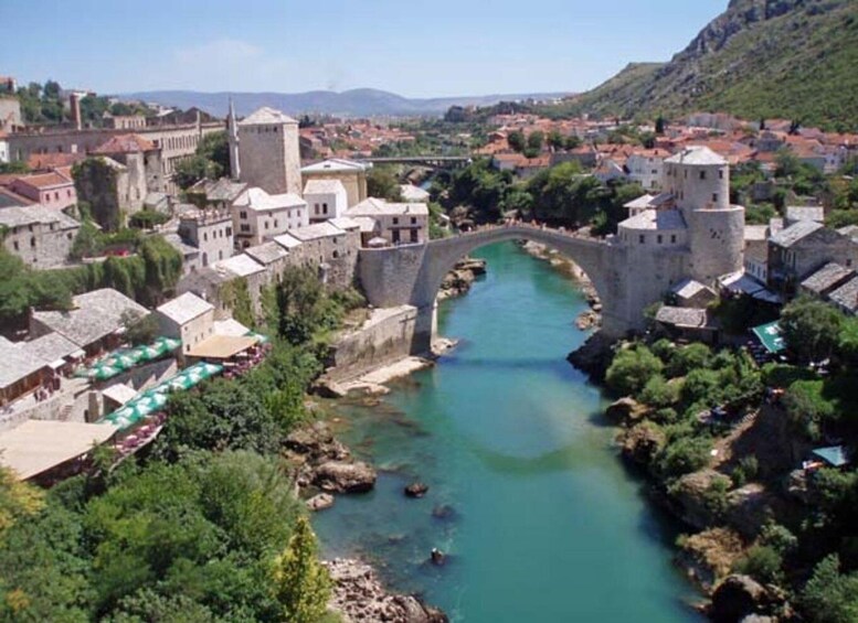 A historic town with a river, stone bridges, and medieval architecture. 2