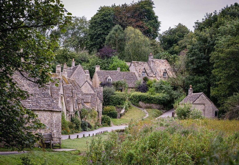 A quaint village with stone houses, a winding path, and lush greenery. 3