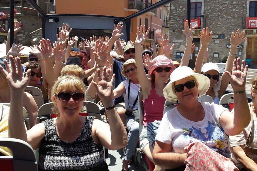 A crowd of people raising their hands, likely at a public event or gathering. 3