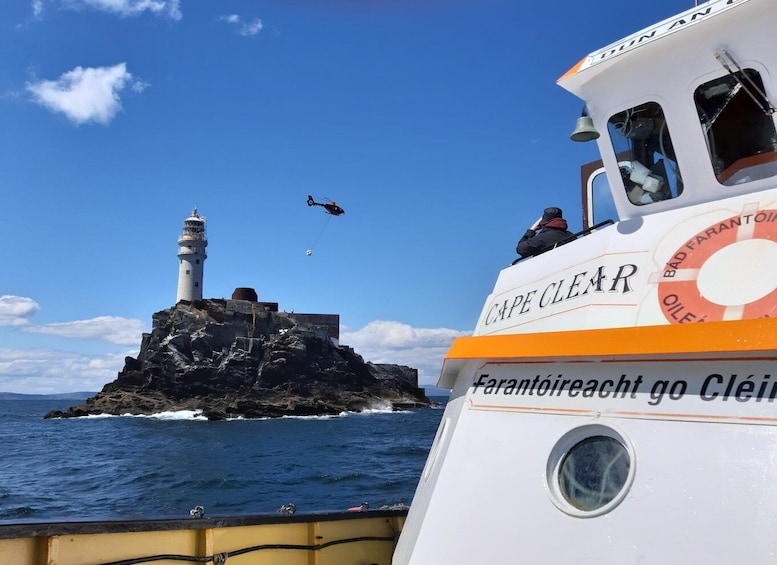 A boat named 'CAPE CLEAR' with a lighthouse in the background. 1