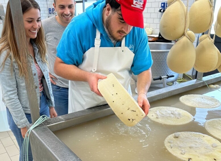 A person pouring a liquid into a large container with several circular objects floating on the surface. 1