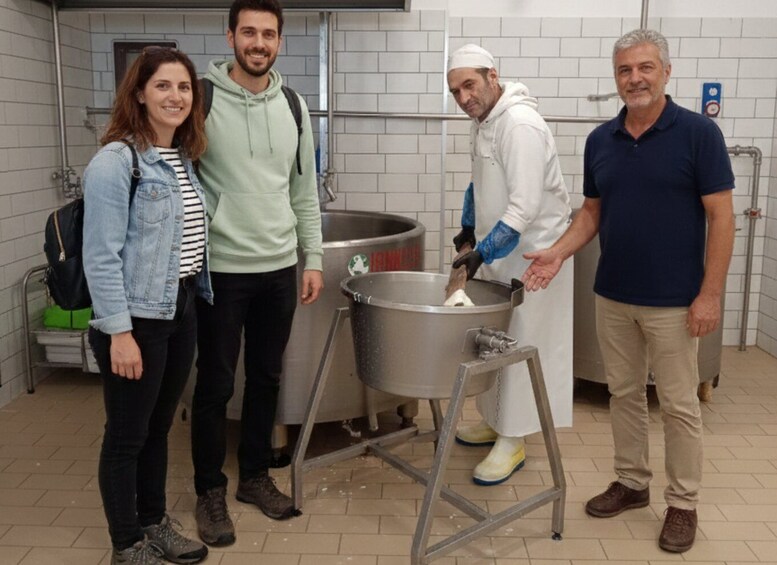 Four people in a kitchen setting with a large pot on a stand. 4