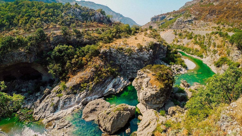 A mountainous landscape with a clear river winding through rocky terrain. 3