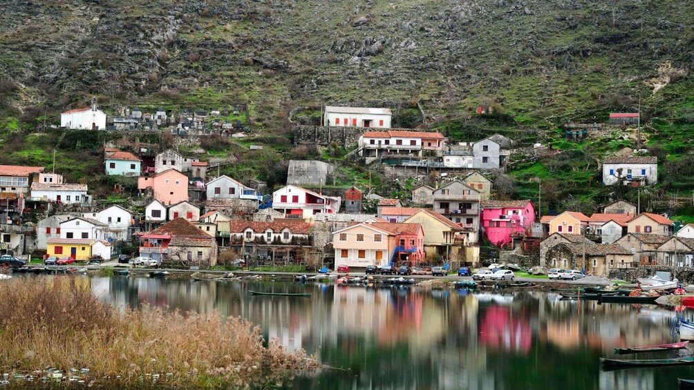 A coastal village with colorful houses, a calm lake, and boats. 5