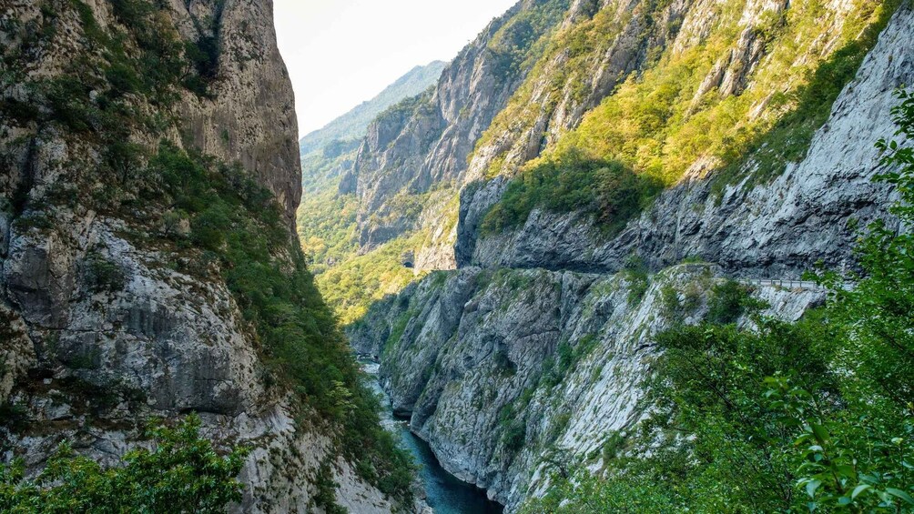 A canyon with steep cliffs and a river flowing through it. 4