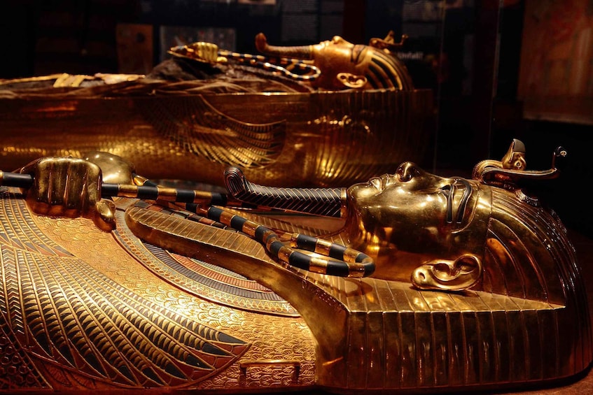 Golden sarcophagi with intricate designs and hieroglyphs. 2