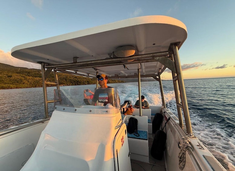 A boat with a canopy, passengers, and a view of the sea and land. 5
