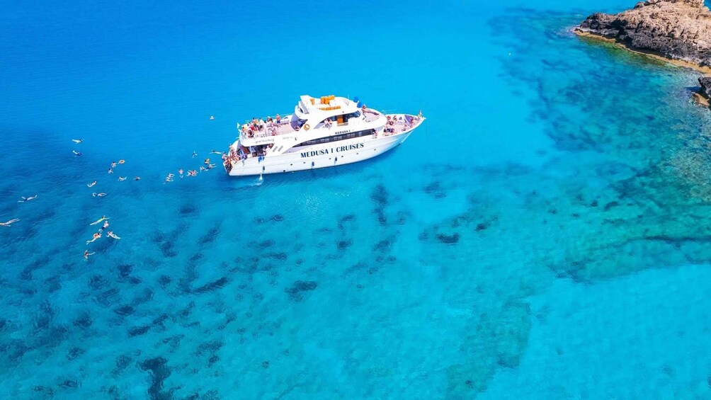 A white cruise ship named 'Medusa I Cruises' with passengers enjoying the water. 1