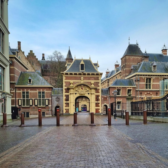A historic building with a prominent archway, brick facades, and a cobblestone street. 5