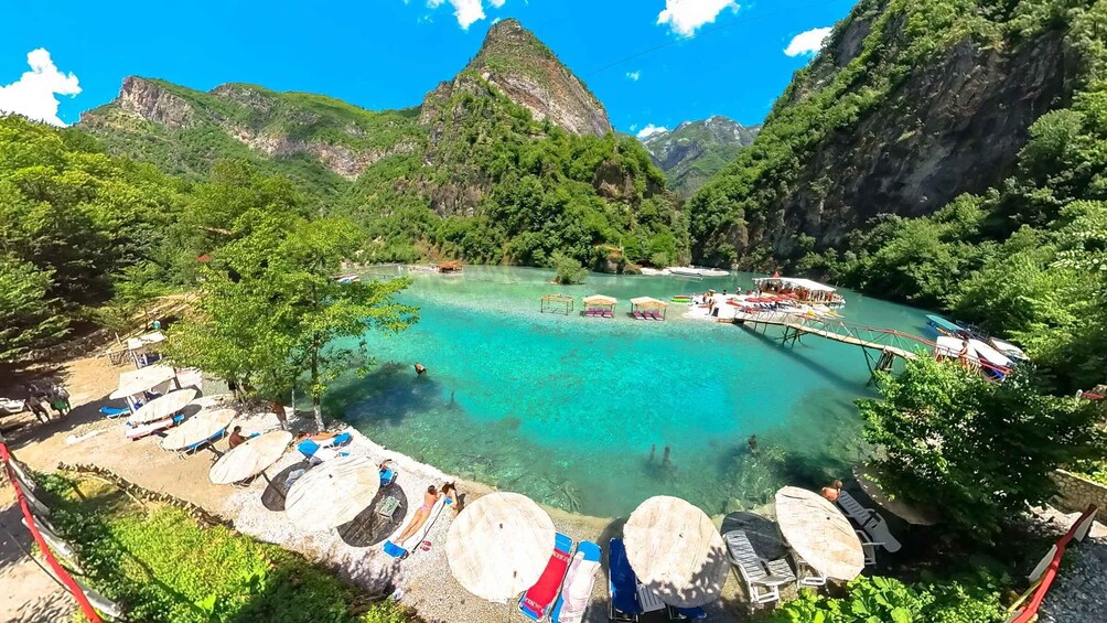 A turquoise lagoon surrounded by lush greenery and mountains. 5