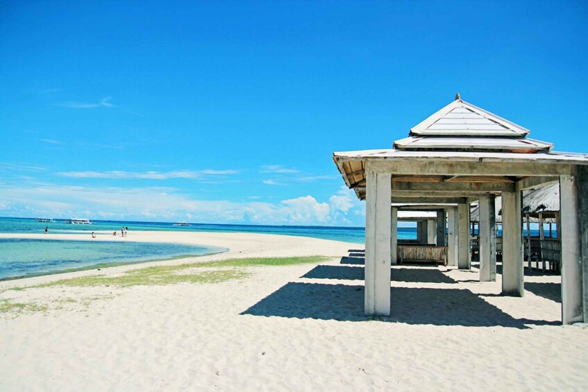 A beach with a concrete structure, clear blue sky, and calm sea. 3