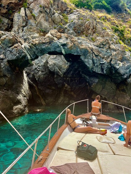 A boat with a rocky shoreline and clear water. 3