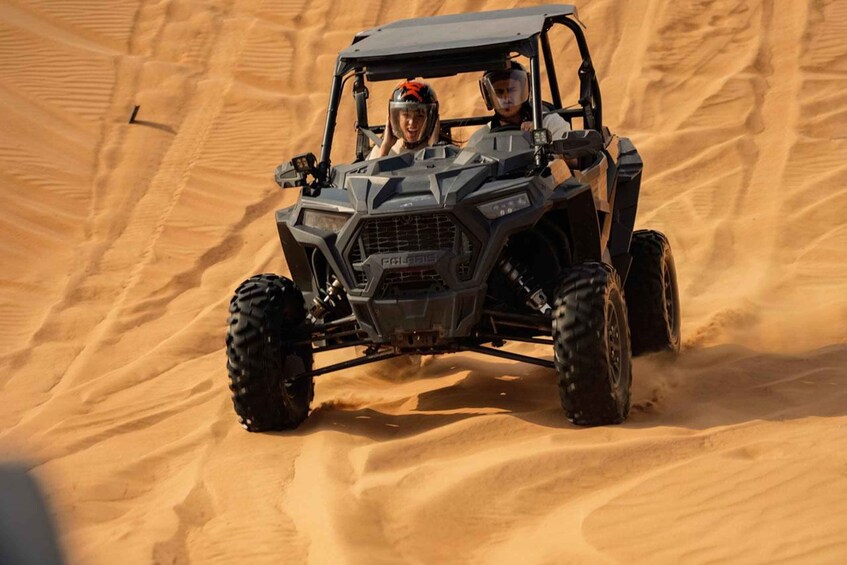 A four-wheeled vehicle on a sandy dune. 1