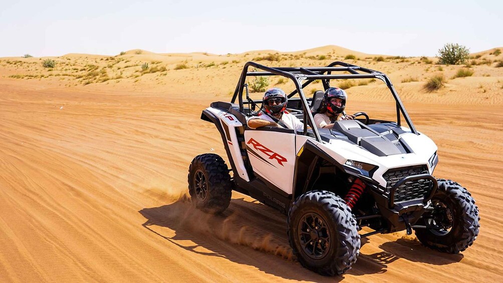 A Polaris off-road vehicle driving on a sandy terrain. 4