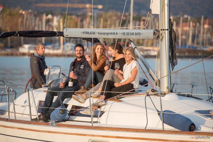 A group of people on a sailboat with a cityscape in the background. 3