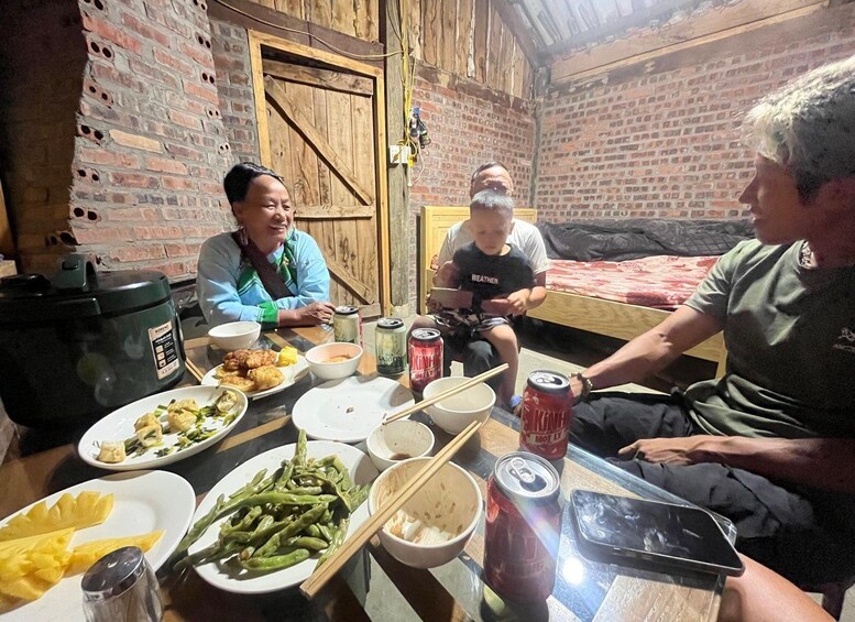 A group of people sitting around a table with various dishes and drinks. 4