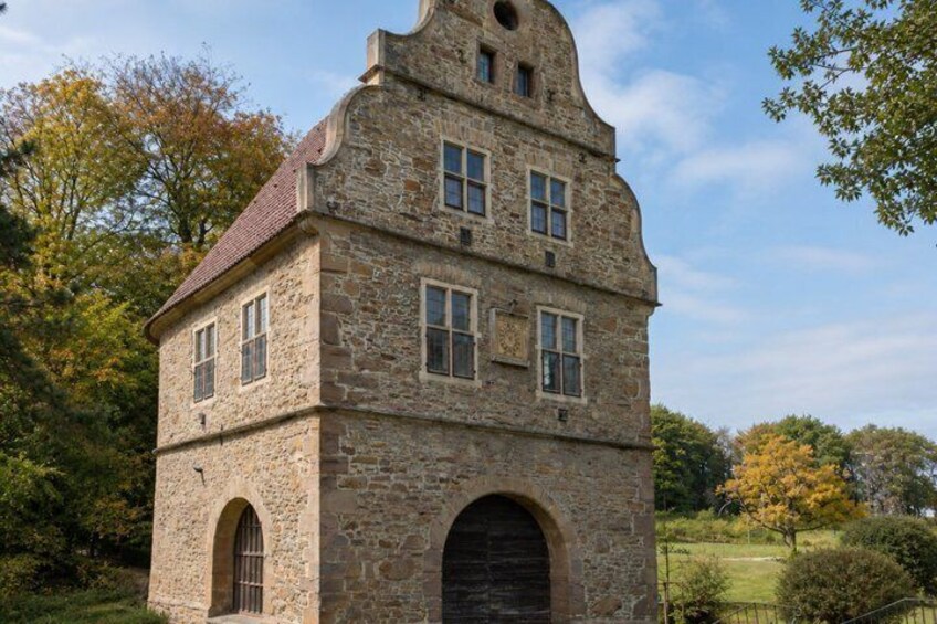 A stone building with arched windows and a steep roof. 4
