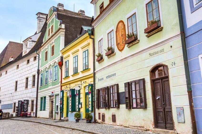 A street with colorful buildings, a café, and a restaurant. 4