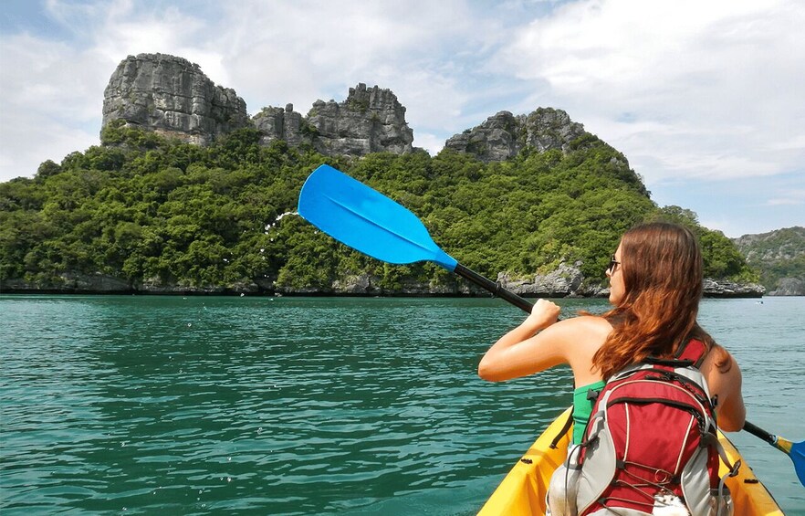 A person kayaking on a calm river with a mountainous landscape in the background. 1