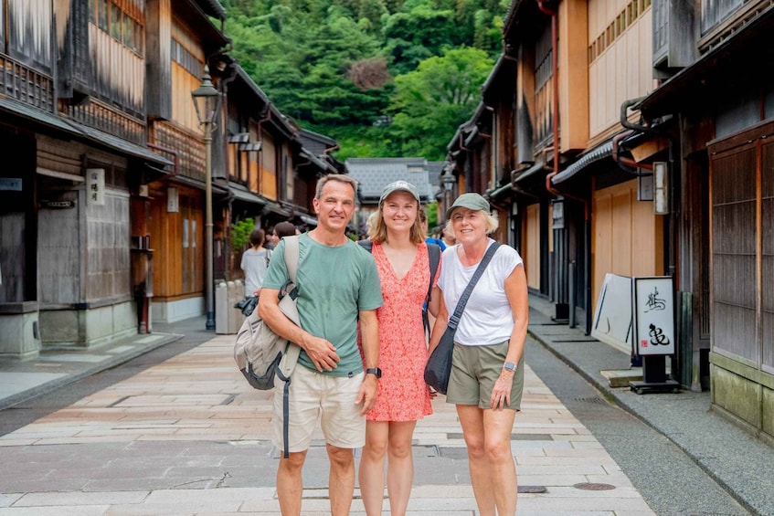 A group of people walking down a narrow street lined with traditional wooden buildings. 3
