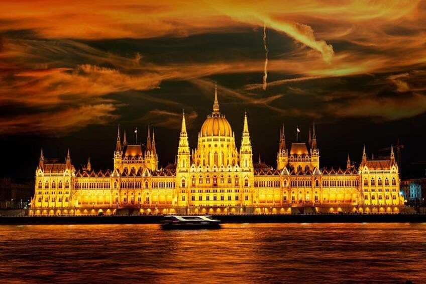 A grand, illuminated building with a prominent dome and multiple spires, reflecting on a body of water. 3