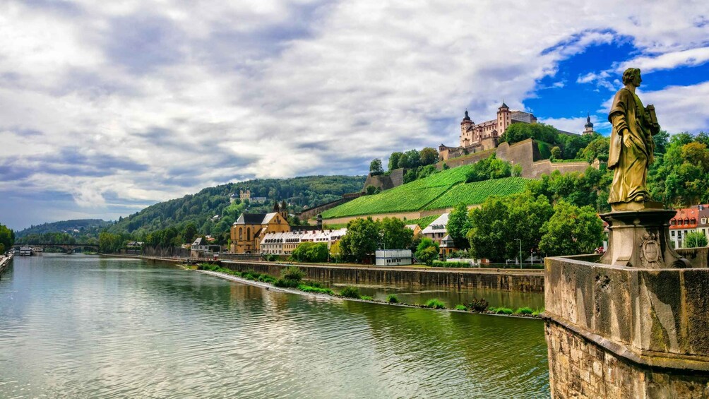 A river with a bridge, a castle on a hill, and a statue. 5