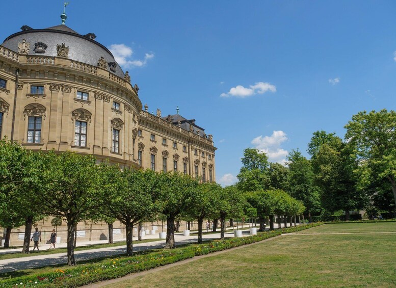 A historic building with a dome, surrounded by a well-maintained garden and trees. 4