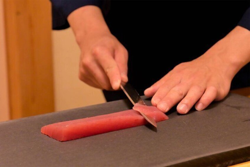 A person sharpening a knife on a stone. 3