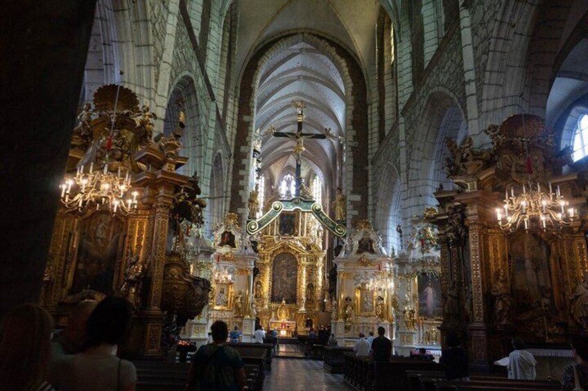 A grand cathedral interior with high vaulted ceilings, ornate altars, and chandeliers. 2