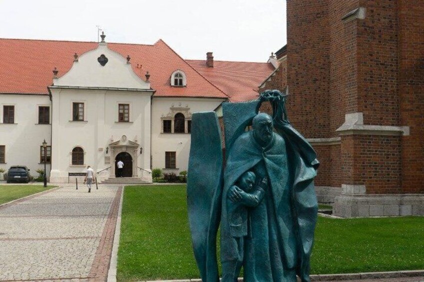 A building with a red roof and a statue of a man holding a child. 3