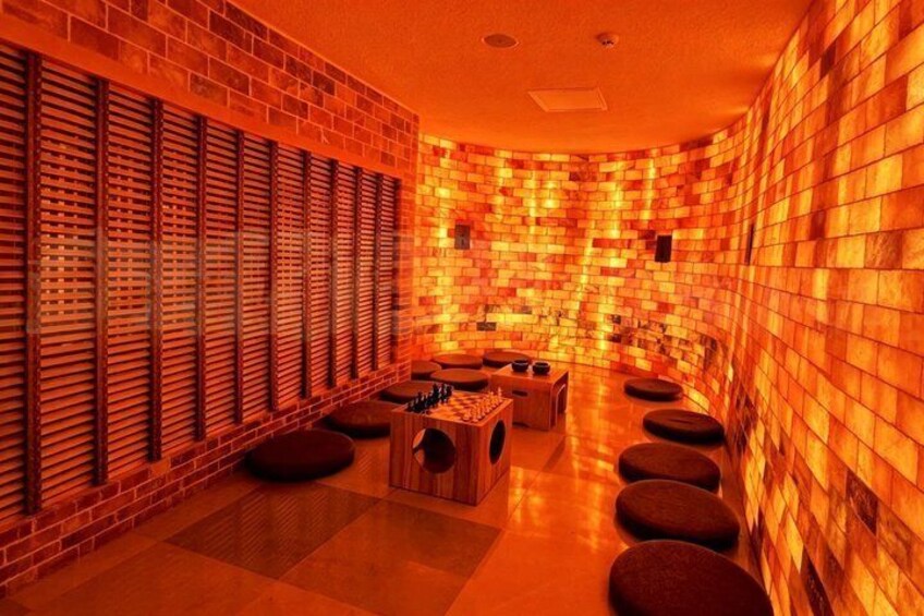 A spa with wooden slatted walls, a wooden bench, and a tiled floor. 3