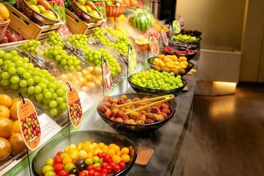 A variety of fruits displayed in a store, including grapes, oranges, and berries. 1