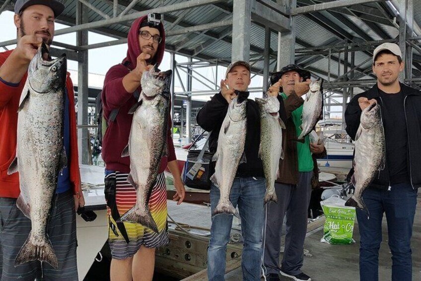 People holding fish, a boat, and a green bag with text. 4
