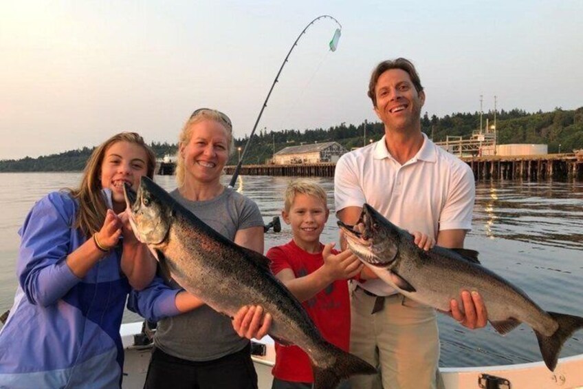 A group of people on a boat holding fish. 2