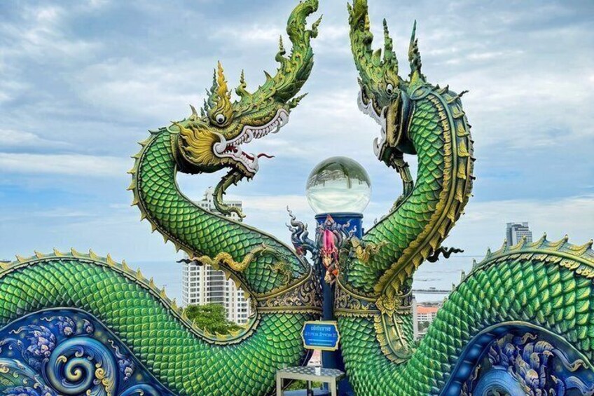 A large green dragon sculpture with a spherical object in the center. 5
