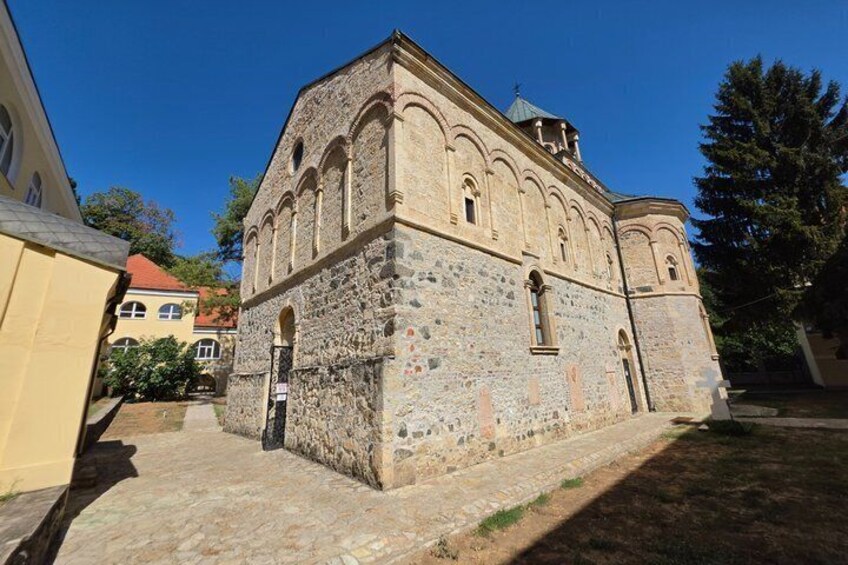 A historic stone building with arched windows and a bell tower. 5