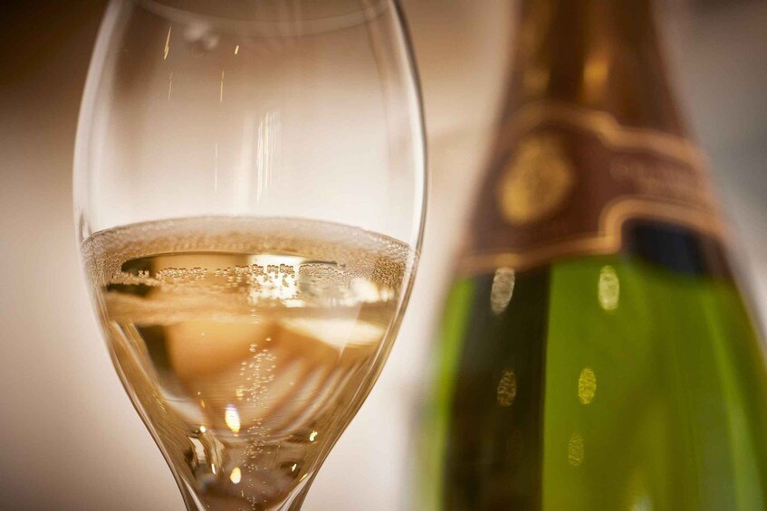 A glass of white wine with a blurred bottle in the background. 5