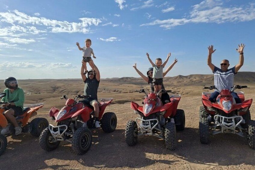 Four people on quad bikes in a desert landscape. 1