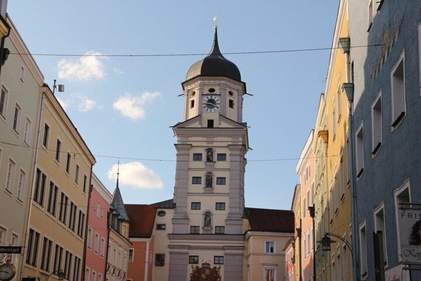 A historic building with a clock tower, surrounded by colorful buildings. 4