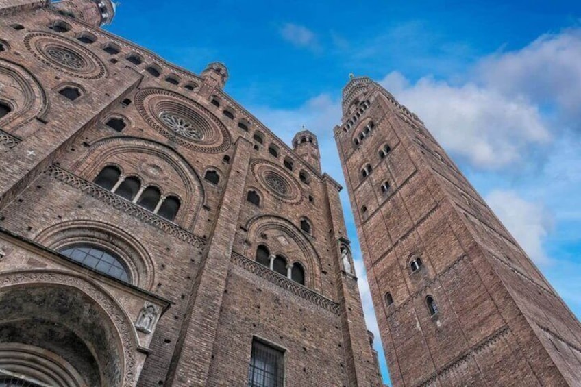 A tall brick tower with circular patterns and a clear blue sky. 2