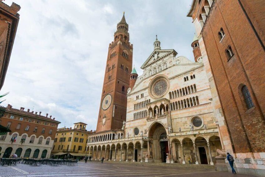 A historic building with a clock tower and arched walkways. 3