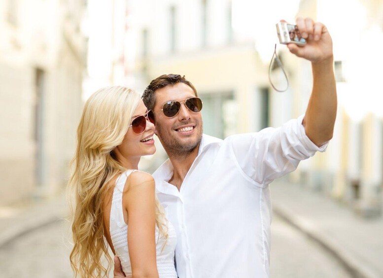 A couple taking a selfie on a city street. 2