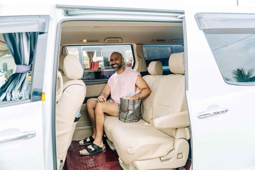 A person sitting in a van with beige leather seats and a window. 2