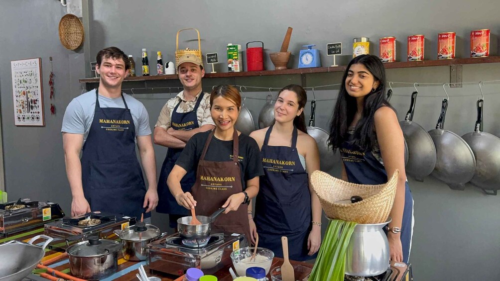 A group of people in a kitchen with cooking utensils and ingredients. 1