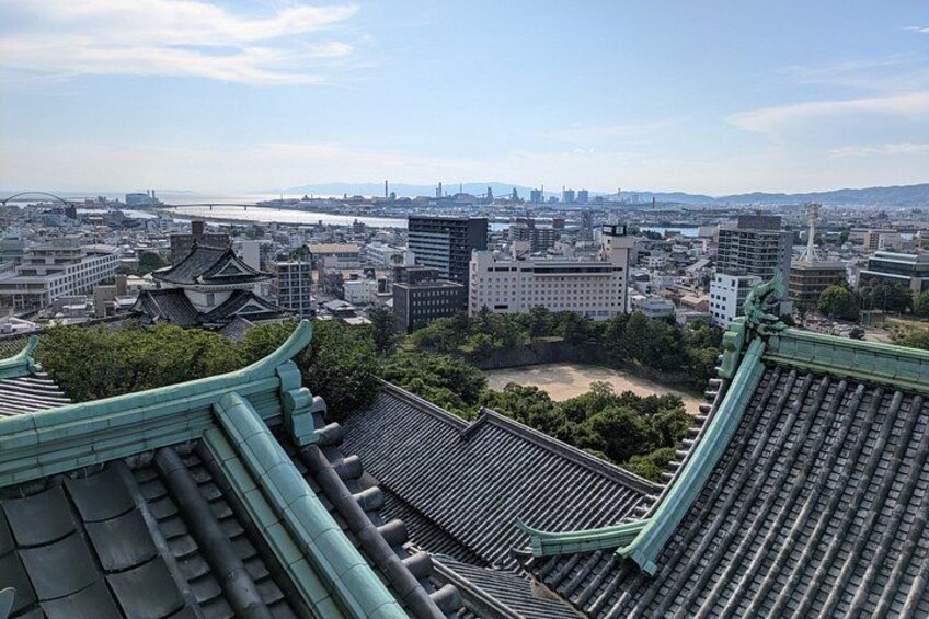 Traditional Japanese architecture, a river, and a cityscape in the background. 4