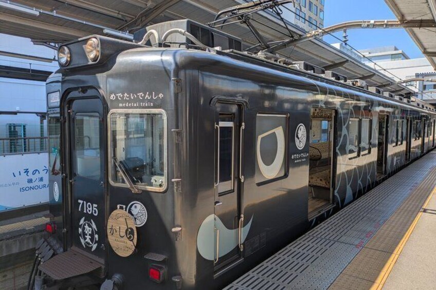 A train at a station with a sign reading 'medetai train' and the number 7195. 3