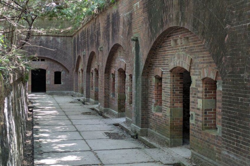 A brick building with arched doorways and a long corridor. 1