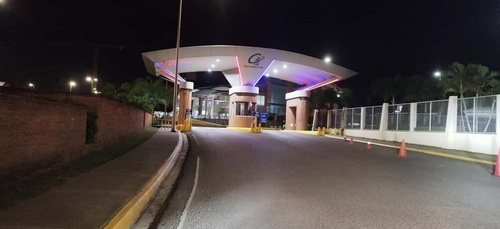 A well-lit toll plaza at night with a modern design, featuring a large canopy and multiple lanes. 1