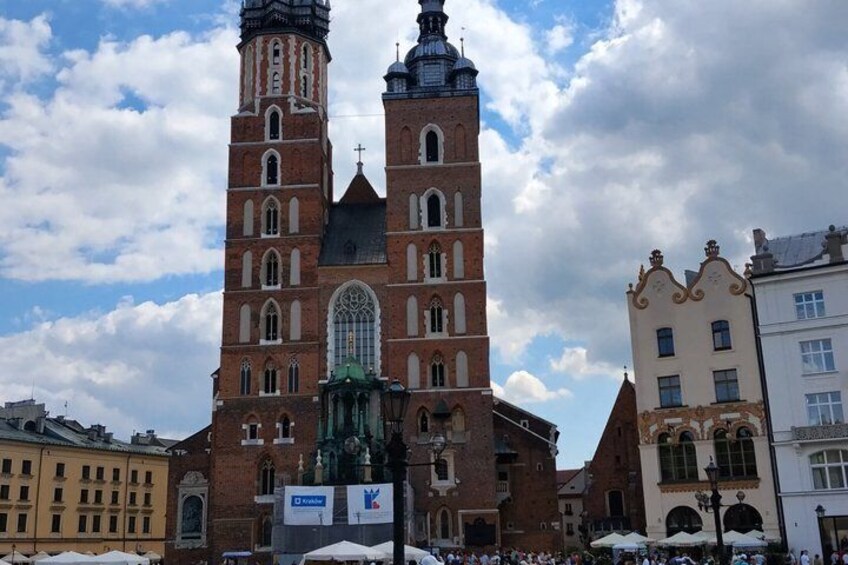 A historic church with two tall towers, a large arched window, and a green dome. 2